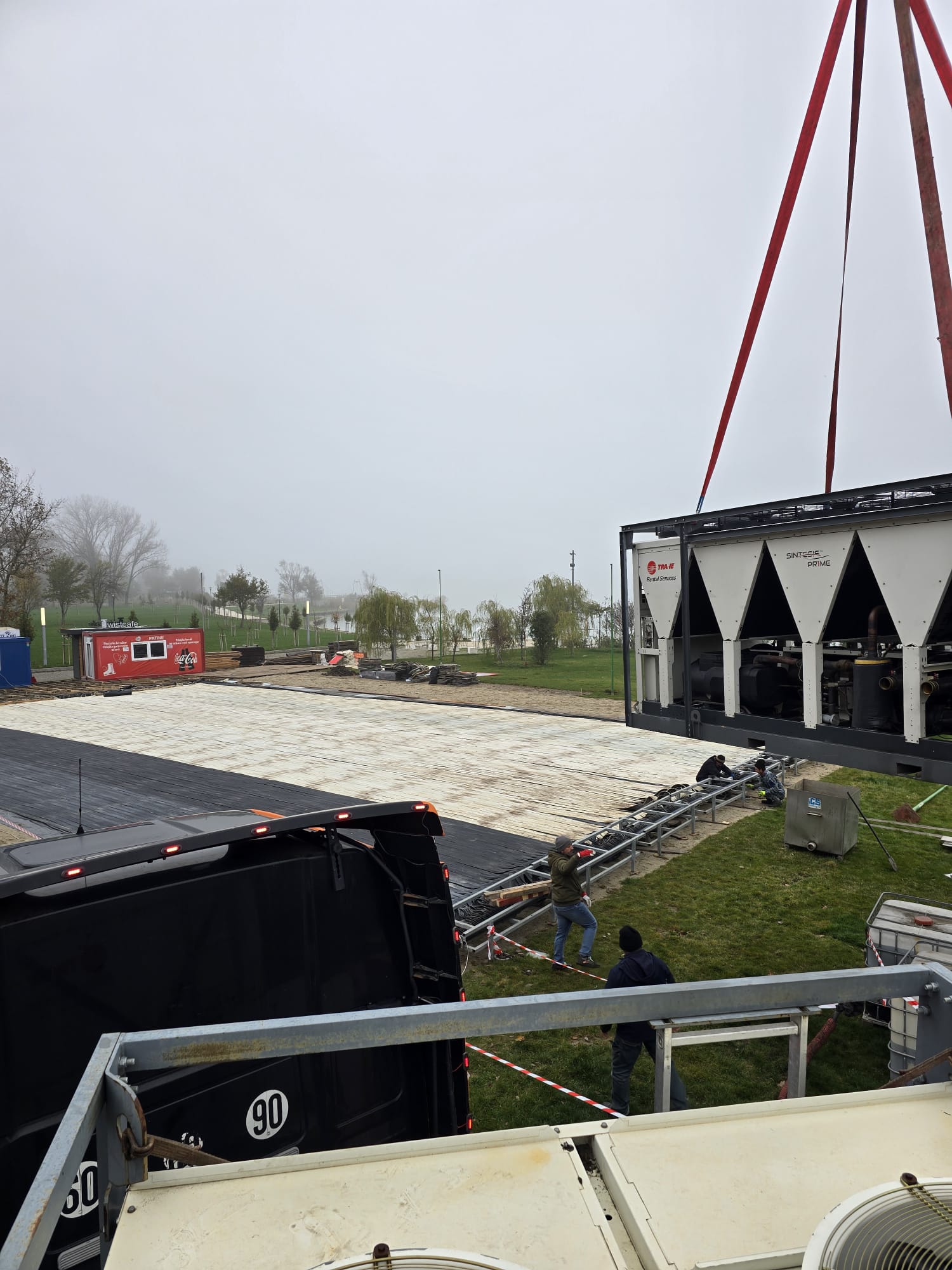 Instalarea unui chiller industrial cu macaraua, lângă pardoseala tehnică a patinoarului